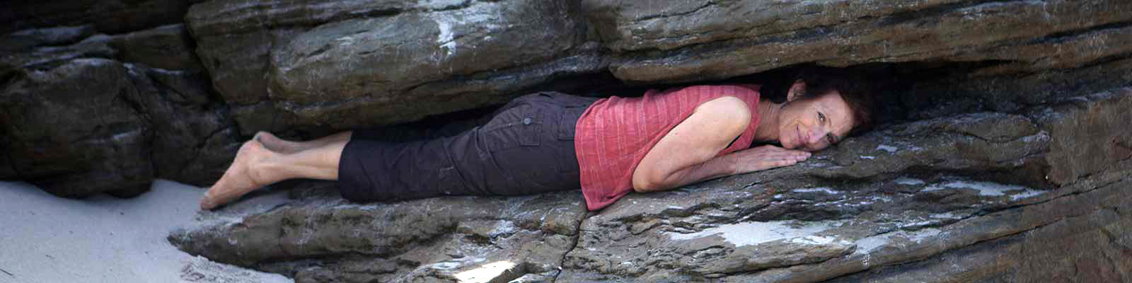 Woman laying between rocks, About Eliana, San Diego